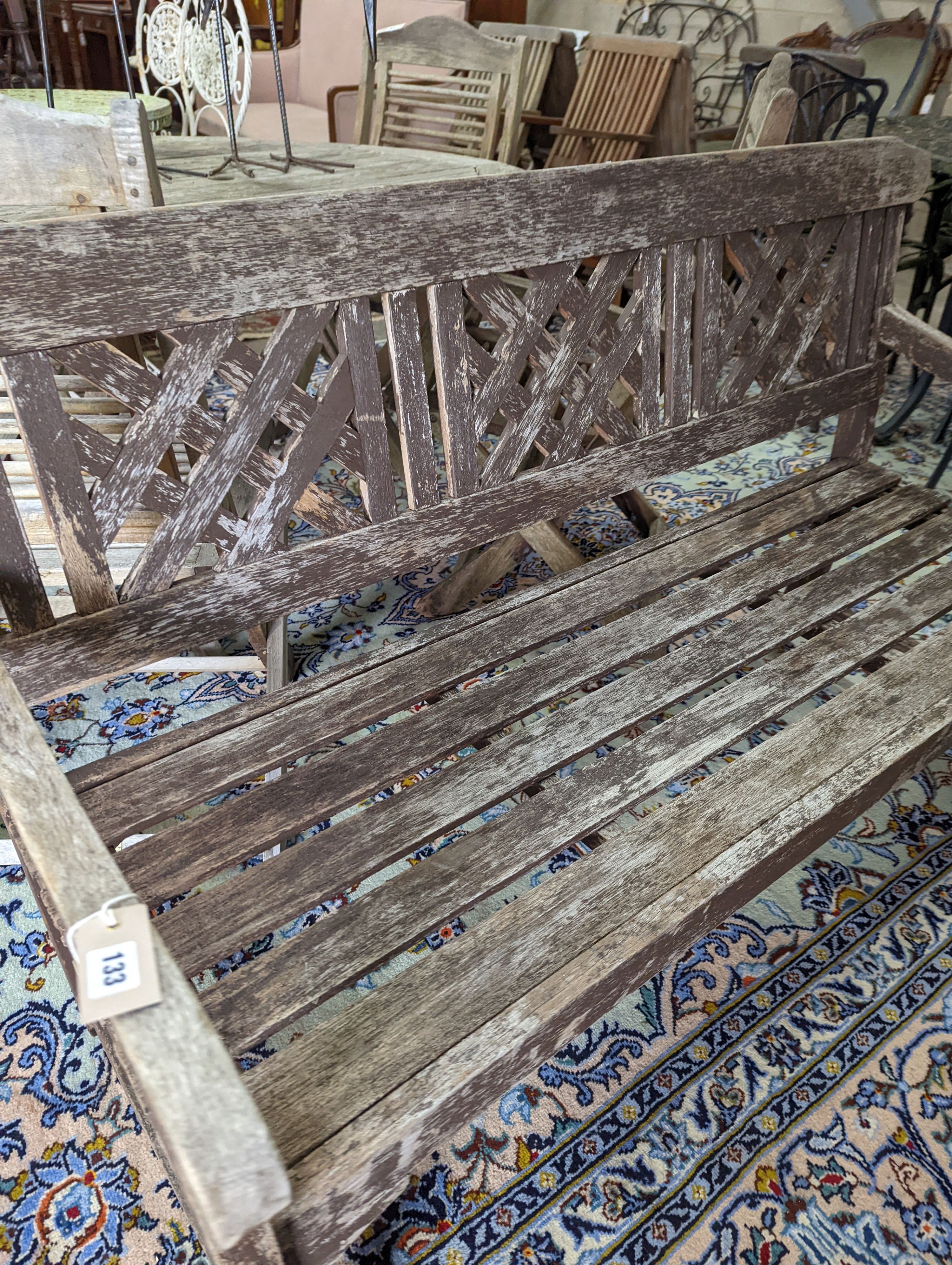 A weathered teak garden bench, length 146cm, depth 50cm, height 86cm